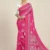 Front view of a model wearing a bright pink printed georgette saree, showcasing the intricate silver-white print and traditional border. Pair this lightweight daily wear saree with a white embroidered blouse for an elegant look.