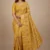 Front view of a model in a vibrant Mustard Yellow Printed Georgette Saree with a traditional woven border. Features intricate floral prints, making it an ideal choice for Haldi ceremonies and festive wear.